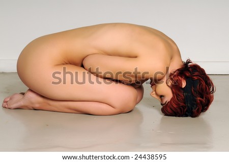 stock photo Nude with punk hair curled up on the floor