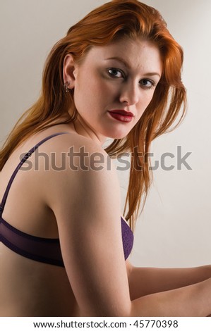 Beautiful young redhead dressed in purple lingerie