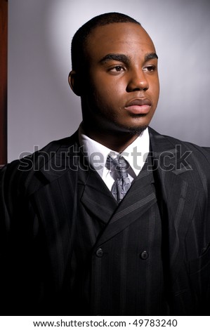 Dramatic portrait of a dignified young black man in a dark suit