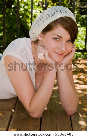 Pretty young brunette on a sun dappled wood deck