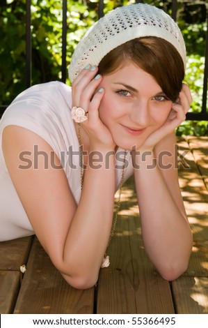 Pretty young brunette on a sun dappled wood deck