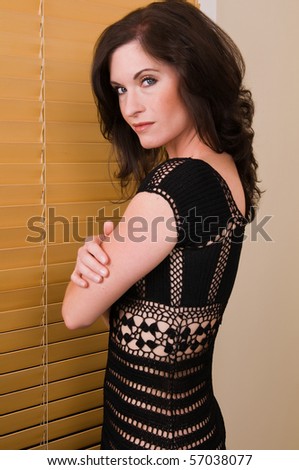 Beautiful brunette in a revealing black knit dress