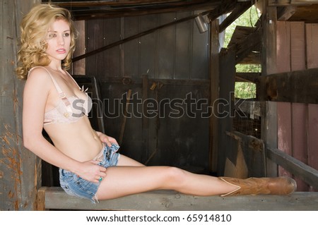 Pretty young blonde in a cream colored bra and jeans shorts