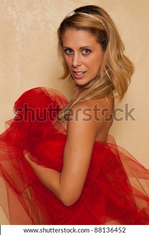 Pretty blonde woman nude wrapped in red tulle