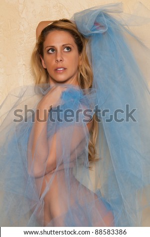 Pretty blonde woman nude wrapped in blue tulle