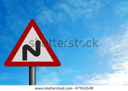 Photo realistic metallic reflective \'double bend\' road sign, against a background of a bright blue summer sky. With space for your text / editorial overlay