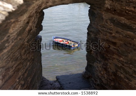 view of a small wooden row boat on the river dart looking through a stone walls window of bayards cove fort dartmouth devon england europe uk taken in july 2006