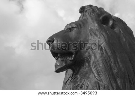 Proud, handsome lion standing guard over Trafalgar Square, London, England - in Black and White.