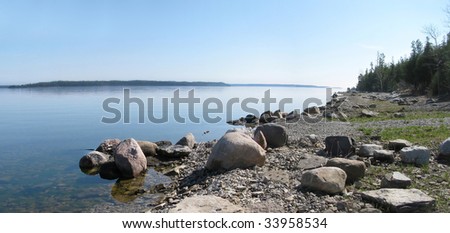 Calm, peaceful water, a rocky shoreline and islands in the distance - a spring day on Georgian Bay, Ontario.
