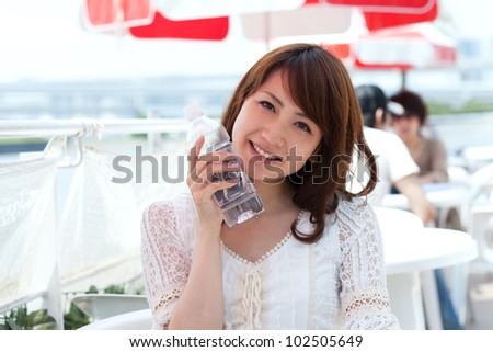 Beautiful young woman drinking water. Portrait of asian woman.