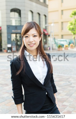 Beautiful business woman walking outside her office. Portrait of asian.