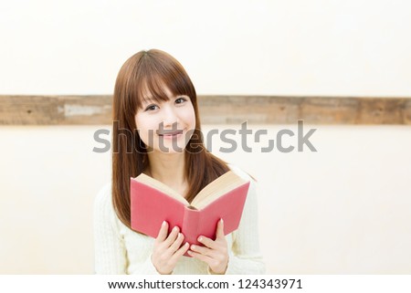 Beautiful young woman reading a book