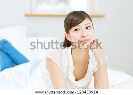 Beautiful asian woman relaxing in bedroom