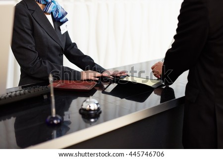 Welcome to the hotel. Male and female receptionists standing at the front desk