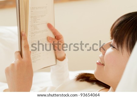Beautiful young woman reading a book. Portrait of asian woman