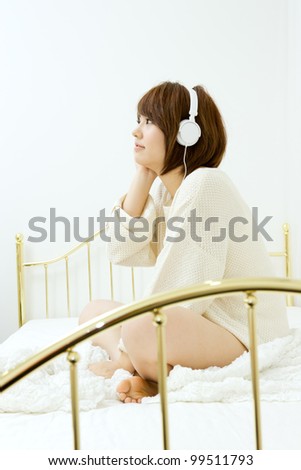 Beautiful young woman relaxing in bedroom. Portrait of asian woman.