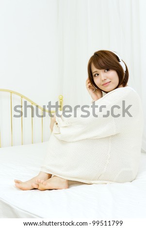 Beautiful young woman relaxing in bedroom. Portrait of asian woman.