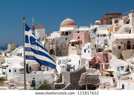 Greek flag with overview on Oia island in Santorini