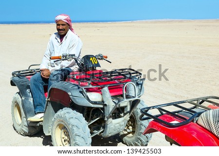 HURGHADA, EGYPT - APR 16: Unidentified local man starting quad trip on the desert near Hurghada on 16 April 2013. Desert safari is one of the main local tourist attraction in Egypt.