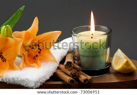 Candle with cinnamon sticks and flowers