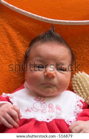 A baby with a punky hairstyle.