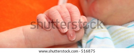 A baby grabbing hold of moms finger (baby about 18 hours old).