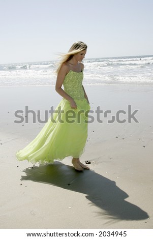 Walking on the beach in an green evening gown