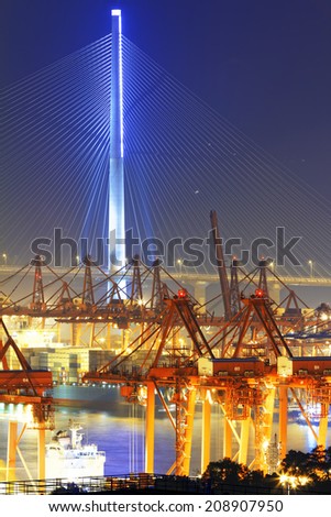 Port warehouse with containers and industrial cargoes at night