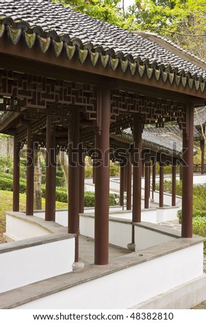 A curved garden path through an Asian garden,it can let the viewer spend more time to walk and more time to admire the garden.It is chinese style.