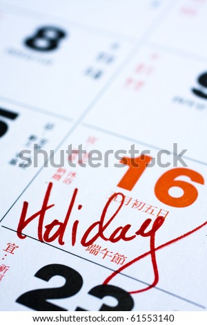 Hand writing holiday important date on calendar.