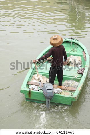 man on sampan boat with outboard motor