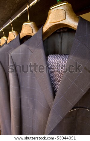 A row of designer suits hanging in a menswear store. Made in Italy
