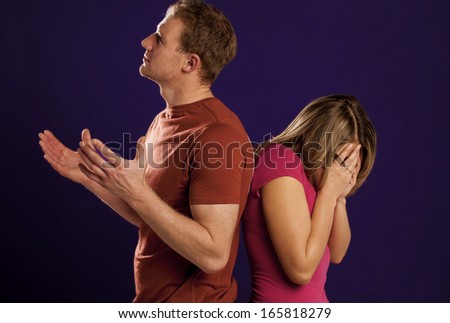 A young couple standing back to back after a fight. Young couple fighting.