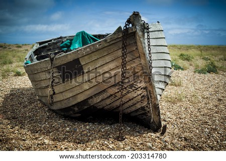 An old abandoned fishing boat stranded on a beech.