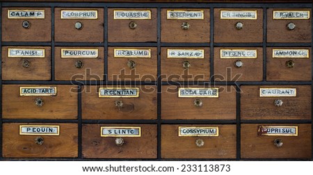Old wooden cabinet of rows of drawers with vintage labels.