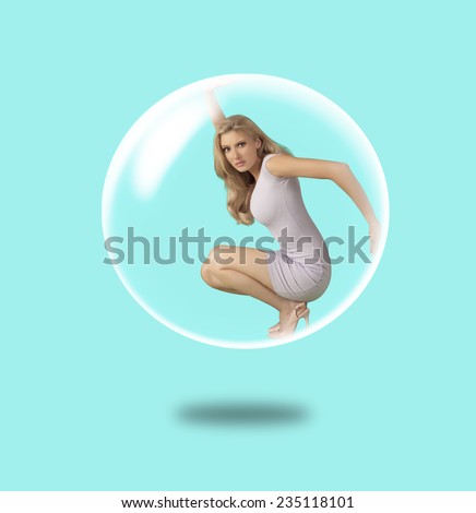 Woman trapped inside a soap bubble over blue background.