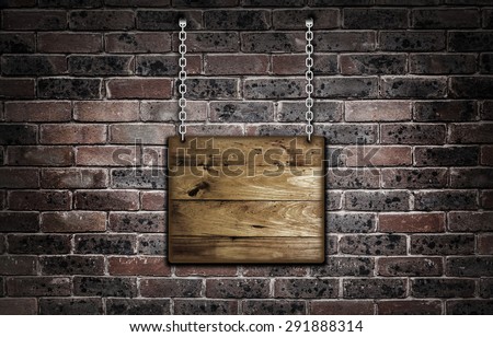 Wooden hanging sign over a old brick wall.