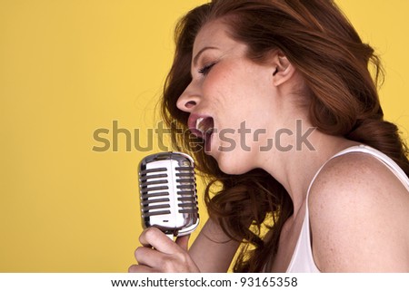 Retro redhead female singer with microphone singing her heart out. Redhead female singer.
