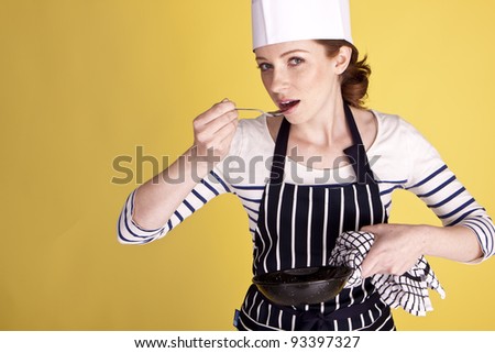 Portrait of an attractive female chef over a yellow background. Beautiful female chef.