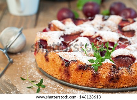 Delicious plum cake with fresh plums in the background, horizontal