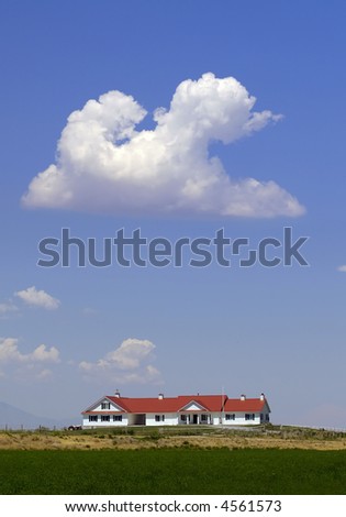 Ranch house on a hill with clouds and sky