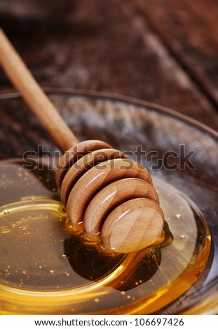 Golden honey with kitchen tool for honey