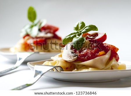 Pasta tagliatelle with tomato sauce and mushrooms