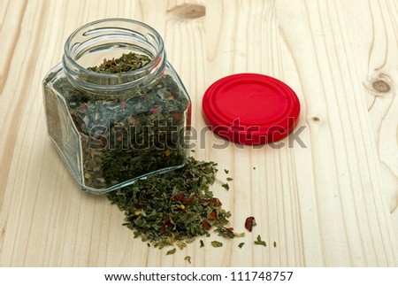 Jar of mixed herbs on wood background