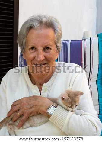 Happy,elderly, senior woman with rescue pet kitten