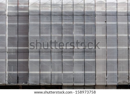 Scaffolding under tarpaulins - building site background