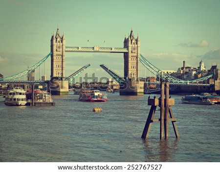 Tower Bridge raised over River Thames. London, England, Retro filtered image. NB logos etc removed.