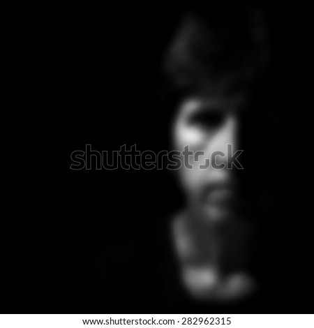 Blurry indistinct female face on black for background. Filtered image.
