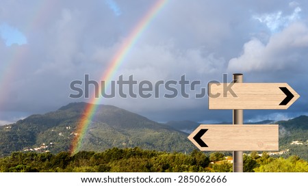 Beautiful double rainbow over landscape with signposts. Life metaphor sun and rain or trekking etc.