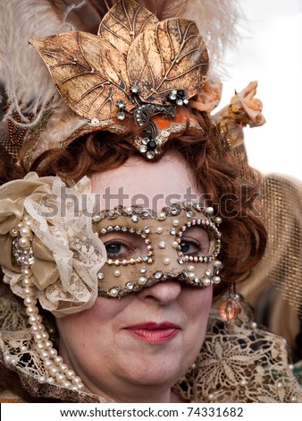 VENICE, ITALY - MARCH 6. Woman wearing typically ornate mask during Venice Carnival, March 6, 2011. The carnival is an annual festival, famous for its costumes, attracting thousands of tourists.